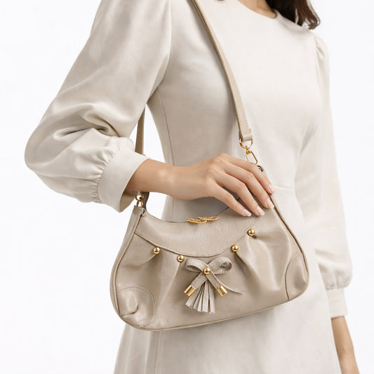Stylish women's shoulder bag with a pleated design, featuring a bow and tassel – made of soft leather with a modern look, suitable for both formal and casual occasions.