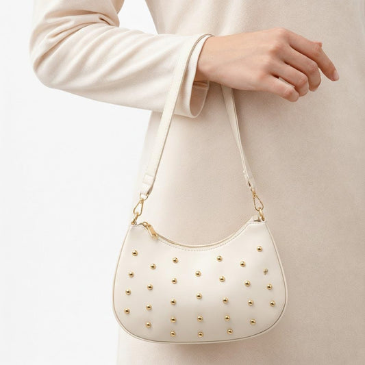 Small women’s shoulder bag decorated with gold studs, featuring a top zipper and a comfortable strap – suitable for outings and evening events.
