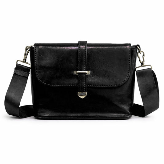 A classic women's crossbody bag in premium leather, featuring a stylish flap design, a distinctive silver metal clasp, and a wide, adjustable strap.