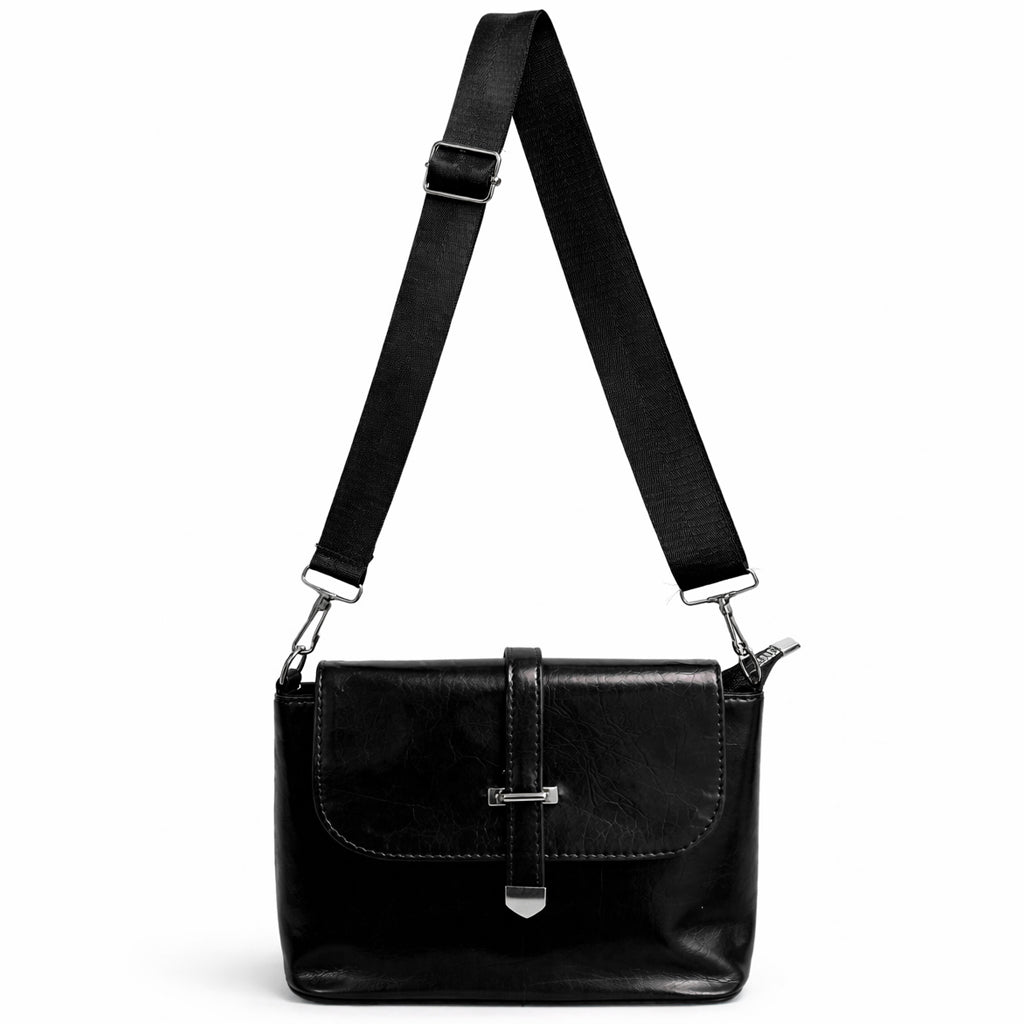 A classic women's crossbody bag in premium leather, featuring a stylish flap design, a distinctive silver metal clasp, and a wide, adjustable strap.