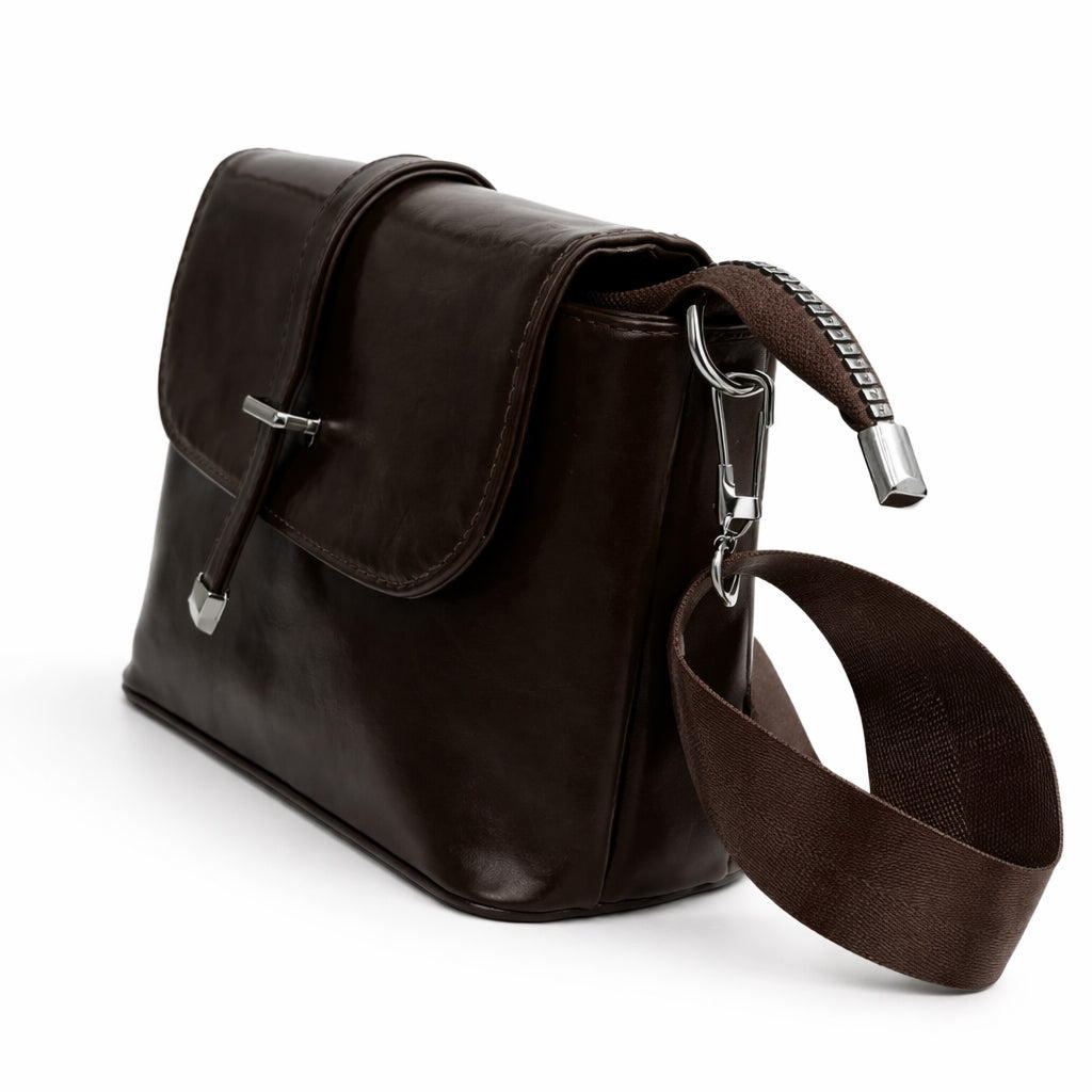 A classic women's crossbody bag in premium leather, featuring a stylish flap design, a distinctive silver metal clasp, and a wide, adjustable strap.